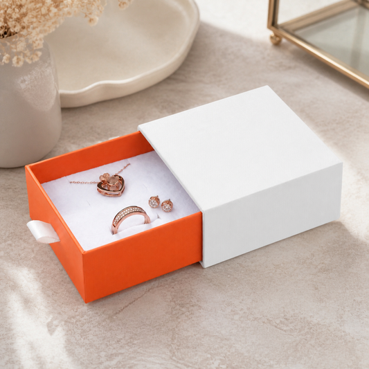 Orange slide drawer box jewelry presented in a boutique jewelry-store display scene.