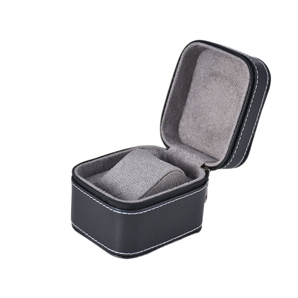 Portable watch organizer for one timepiece with a square black exterior, zipper closure, and cushioned lining.