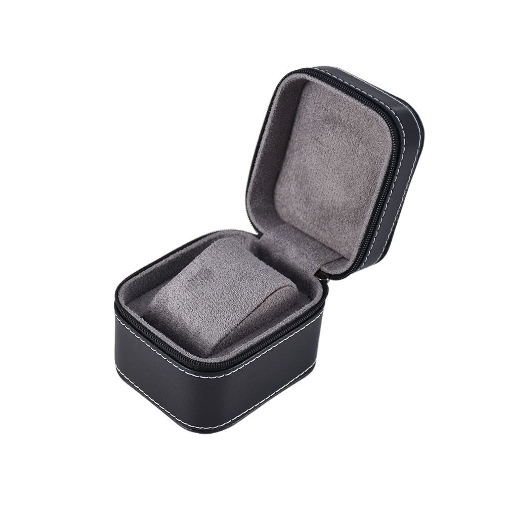 Open black single watch travel case with gray padded lining and a fitted cushion on a white background.