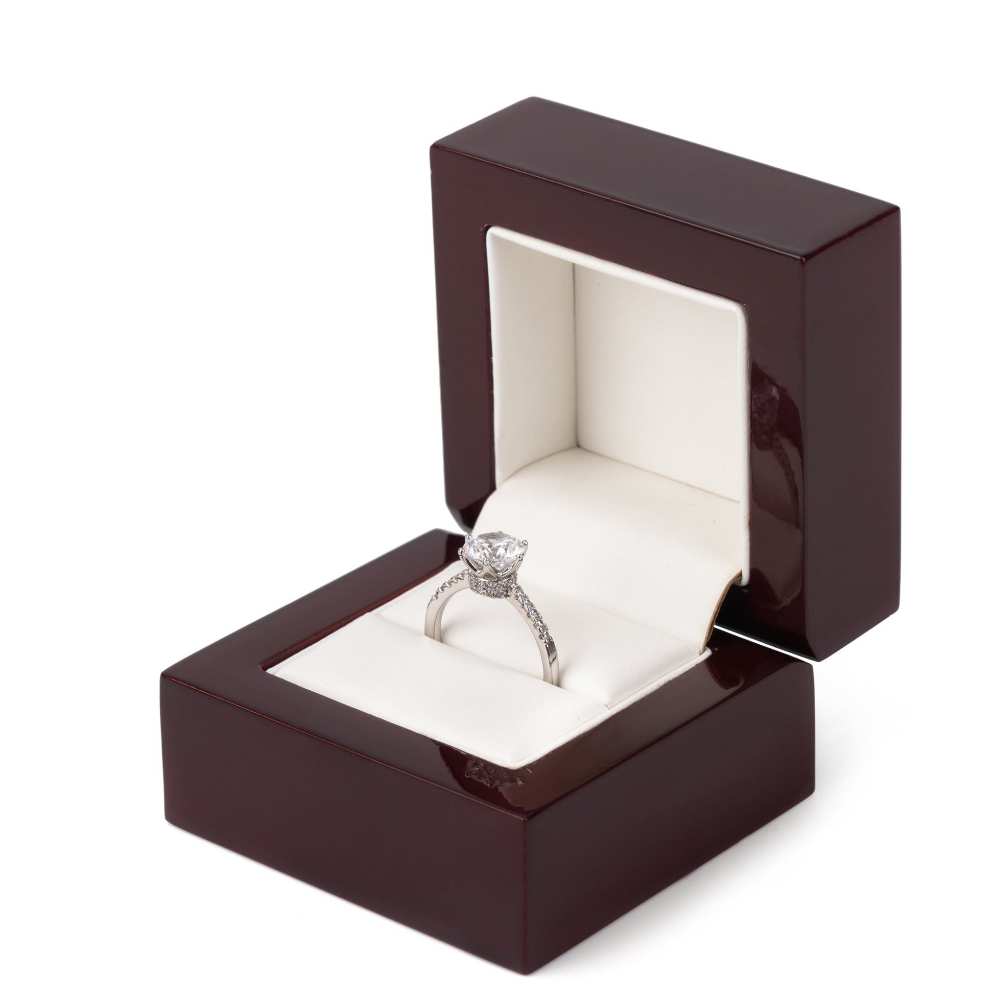 Open burgundy wooden engagement ring box with glossy finish, white padded interior, and diamond ring