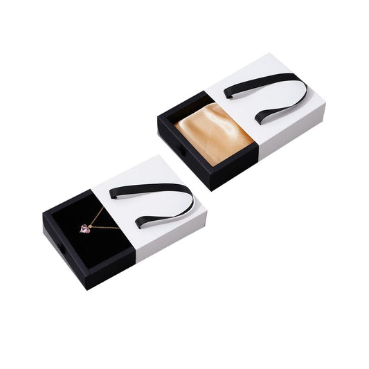 Custom black and white foldable drawer jewelry box with satin insert and ribbon handle on pure white background