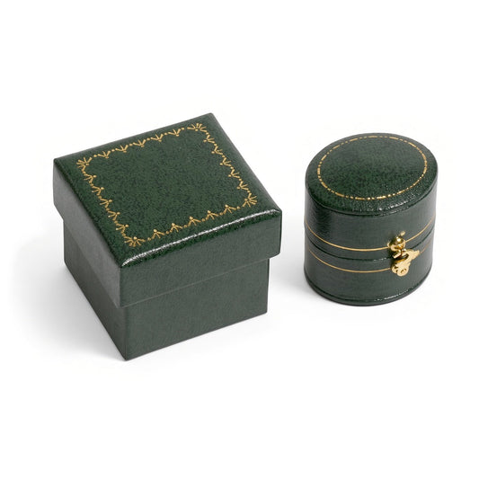 Dark green oval clasp jewelry box beside a square box with gold border decoration