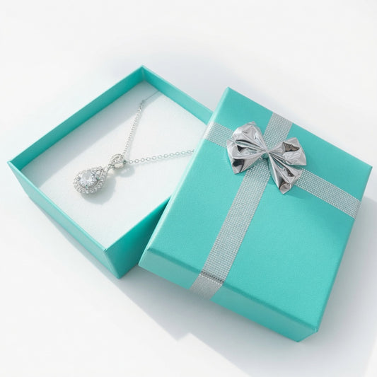 Open lake blue paper pendant box displaying a silver necklace