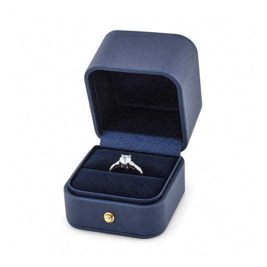 navy blue PU ring box open in a three-quarter view with a diamond ring.
